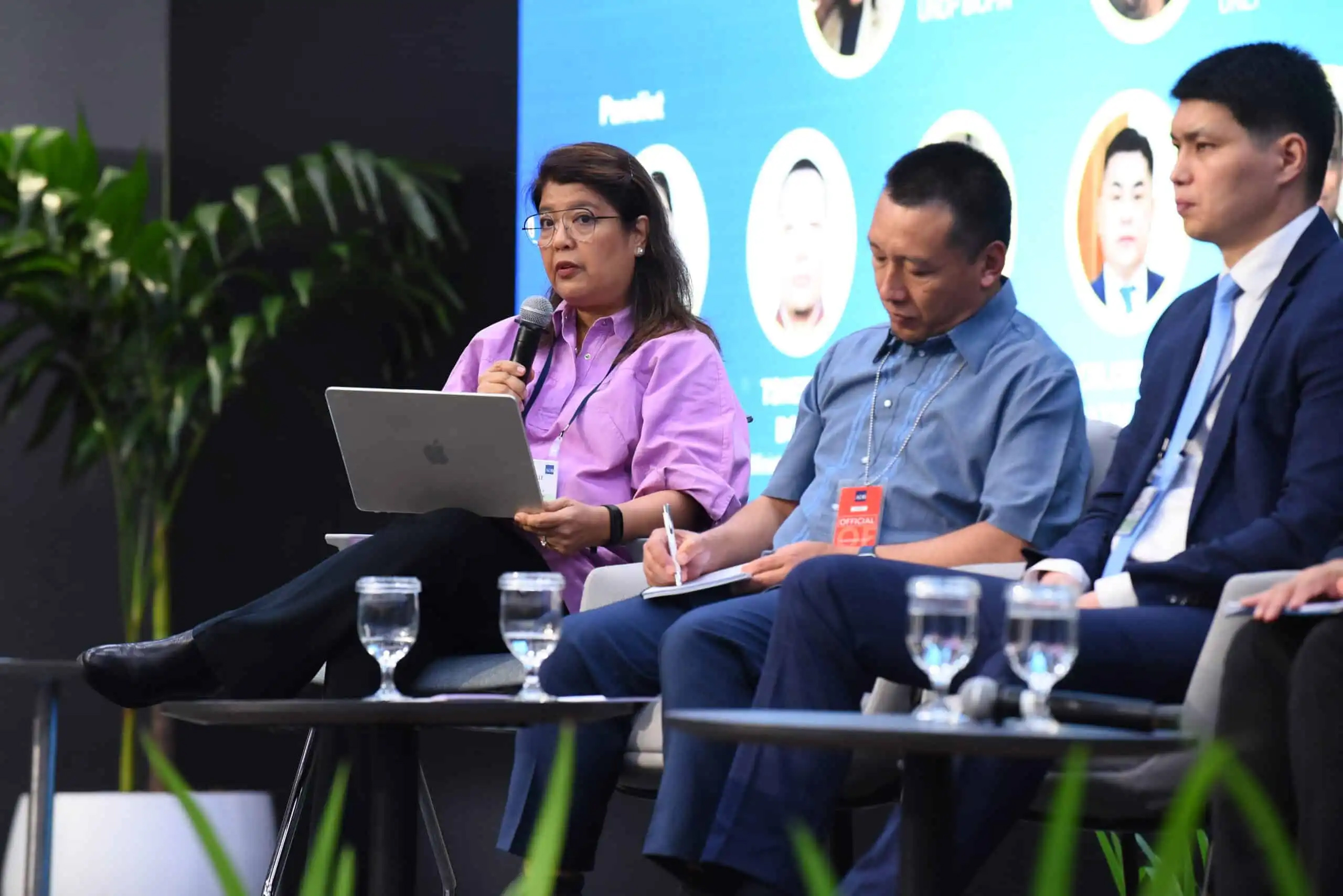 People in a panel - Asian woman speaking into a mic