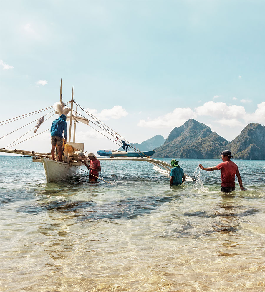 fishermen in shallow waters with fishing boat